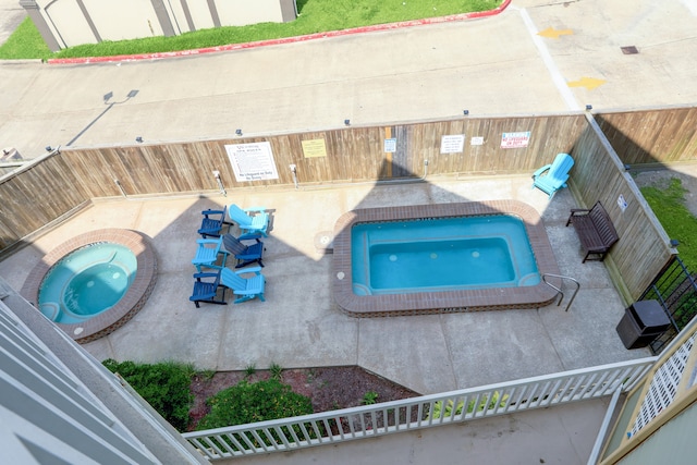 view of swimming pool with a community hot tub and a patio area