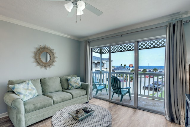 living room with a wealth of natural light, ceiling fan, light wood-type flooring, and a water view