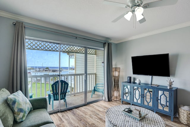 living room featuring hardwood / wood-style floors, ceiling fan, and crown molding