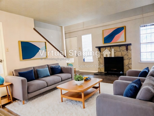 living room with hardwood / wood-style floors and a stone fireplace