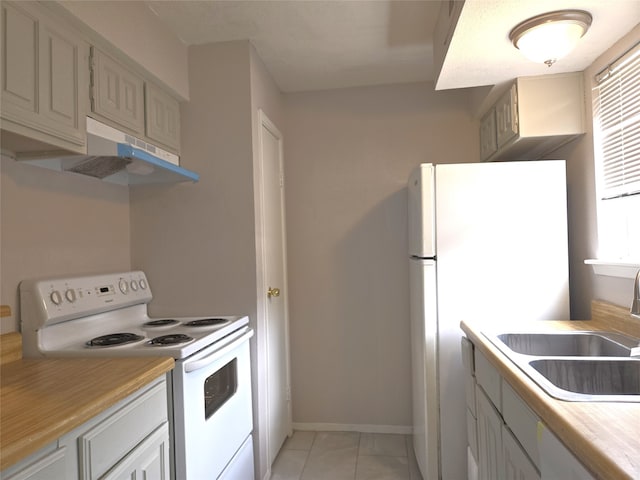 kitchen with sink, white appliances, and light tile patterned flooring