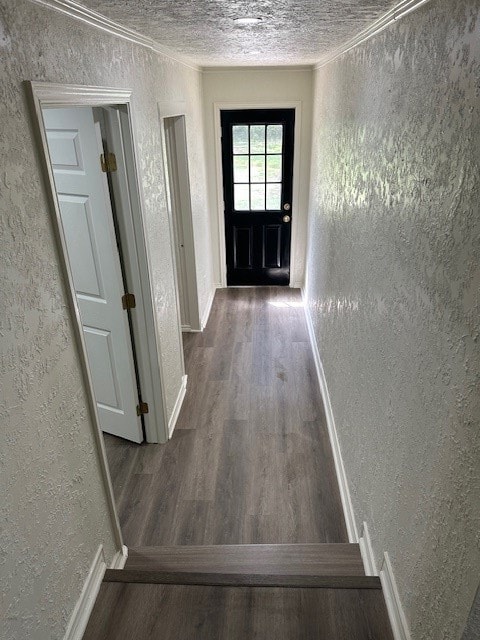 interior space featuring a textured ceiling, ornamental molding, and hardwood / wood-style floors