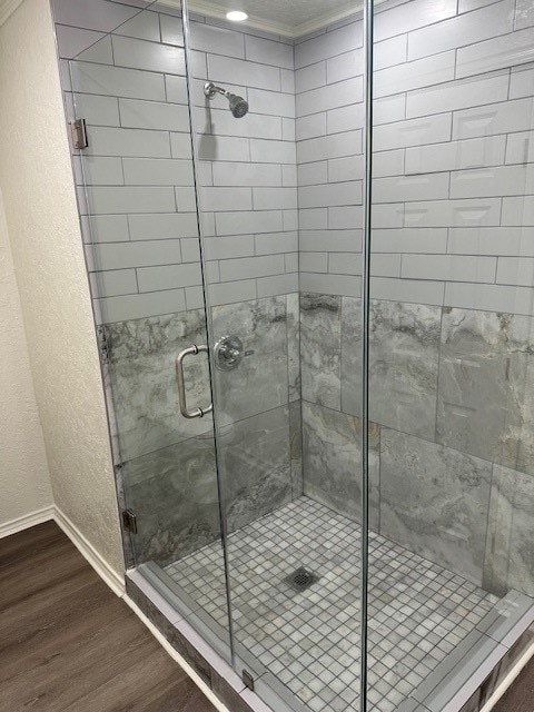 bathroom with hardwood / wood-style flooring and a shower with door