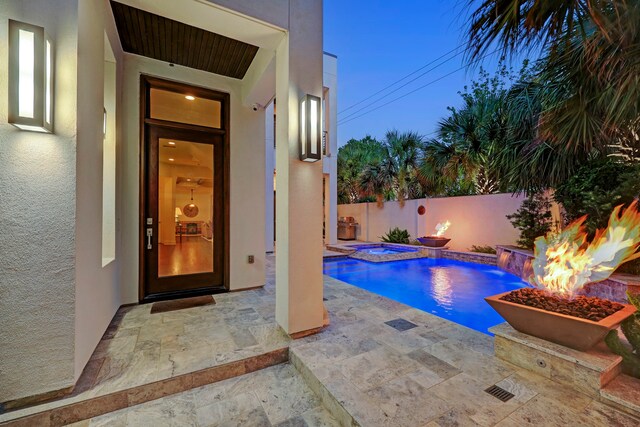 view of pool featuring an in ground hot tub, pool water feature, and a patio