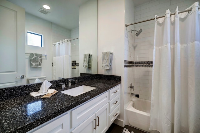 bathroom featuring shower / bath combo with shower curtain and vanity