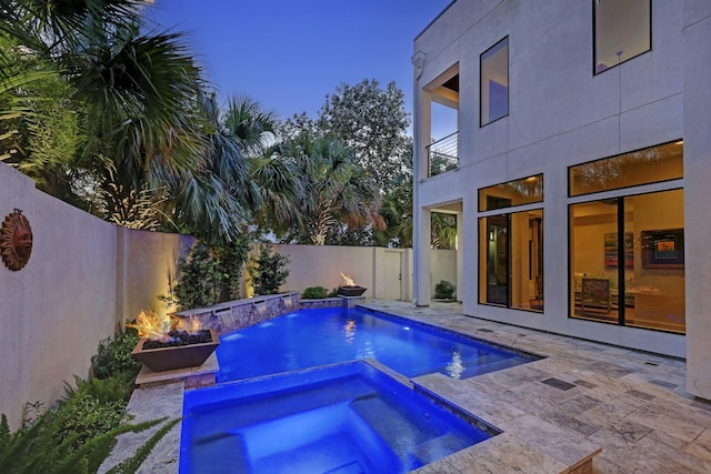 view of swimming pool with a patio, a fenced backyard, and a pool with connected hot tub