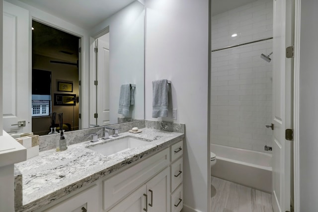 full bathroom with tiled shower / bath combo, vanity, toilet, and hardwood / wood-style flooring