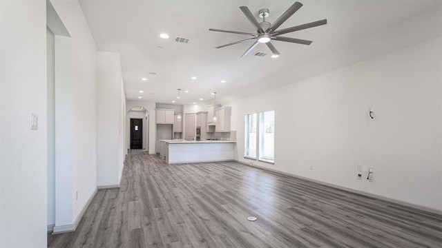 unfurnished living room with light wood-type flooring, visible vents, ceiling fan, and recessed lighting