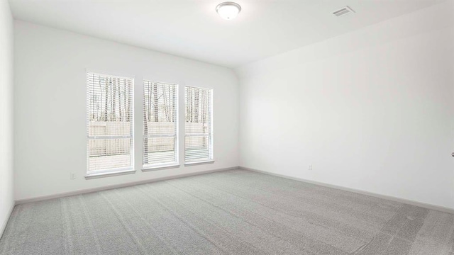 carpeted empty room featuring visible vents and baseboards