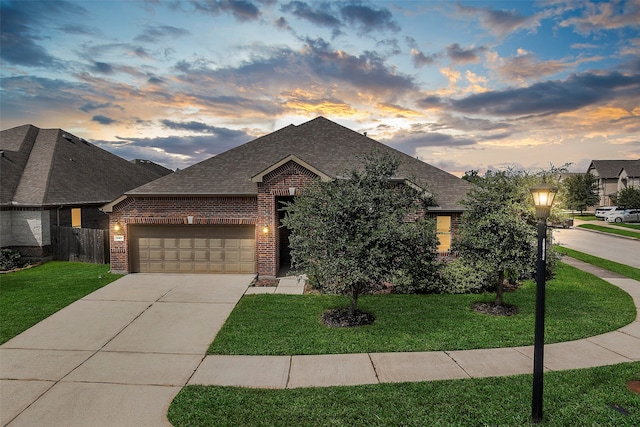 view of front of home with a garage and a yard