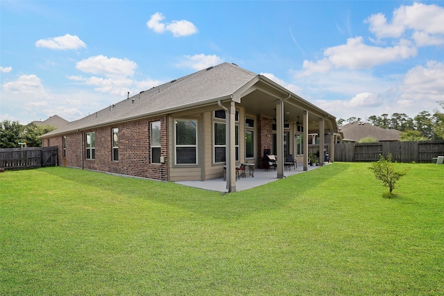 back of property with a yard and a patio