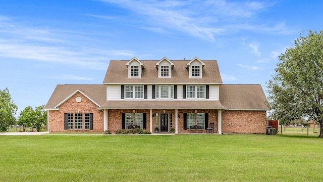 view of front facade featuring brick siding, a shingled roof, central AC unit, and a front yard