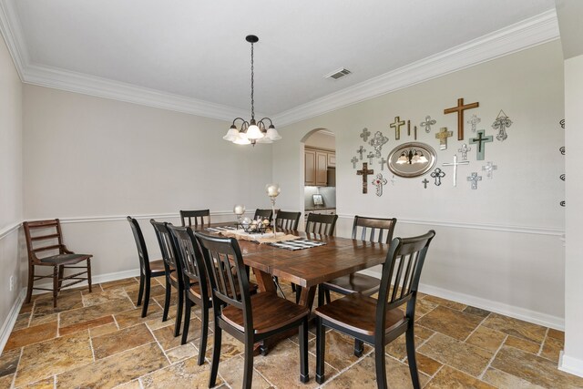 dining space with arched walkways, stone tile flooring, visible vents, and baseboards