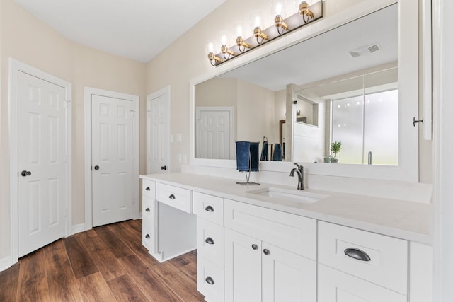 bathroom with visible vents, wood finished floors, and vanity