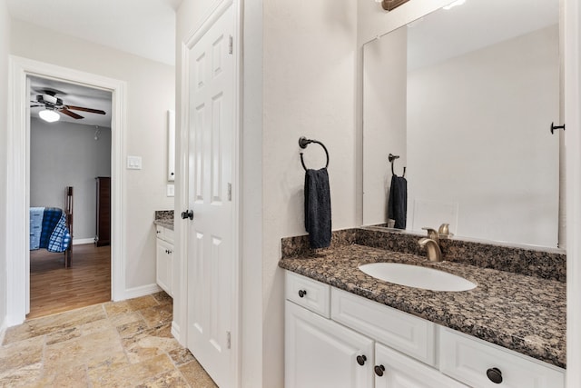 bathroom with stone finish flooring, ceiling fan, vanity, and baseboards