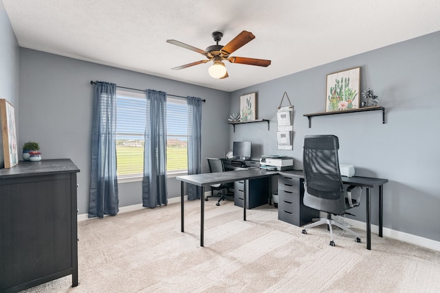 office space with light carpet, ceiling fan, and baseboards