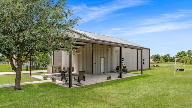 rear view of house featuring a yard, metal roof, and a patio