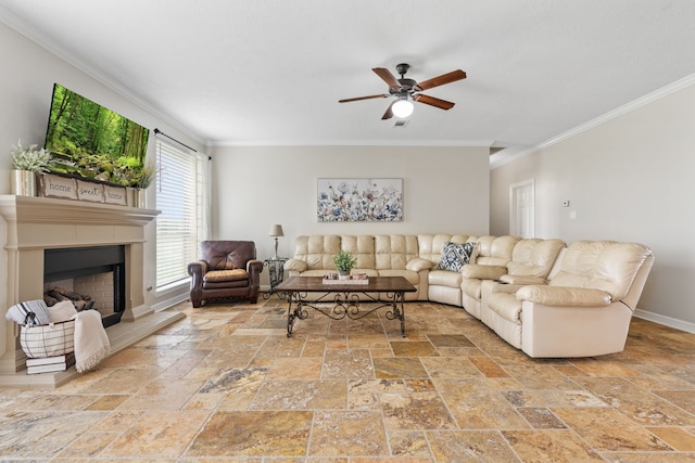 living room featuring baseboards, a fireplace with raised hearth, a ceiling fan, ornamental molding, and stone tile flooring