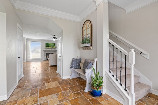 interior space with stairway, stone tile floors, baseboards, and crown molding