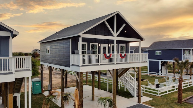 view of front facade with a patio, fence, stairs, a carport, and board and batten siding