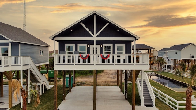 back house at dusk featuring a porch