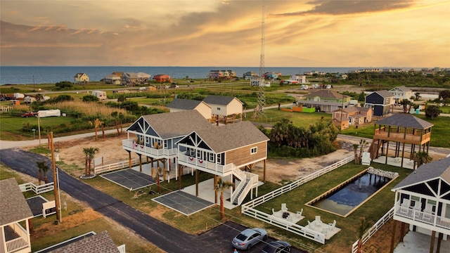 aerial view at dusk featuring a water view