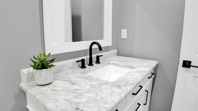 bathroom with a textured wall and vanity