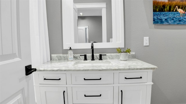 bathroom with a textured wall and vanity