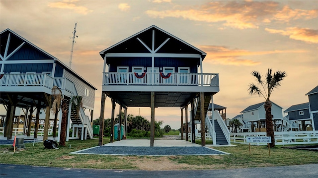 view of front of home with stairs, board and batten siding, and a yard