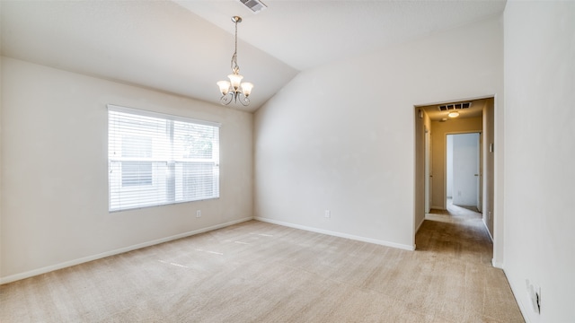 carpeted spare room featuring lofted ceiling and an inviting chandelier