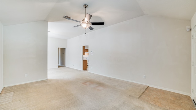 empty room featuring lofted ceiling, ceiling fan, and light colored carpet