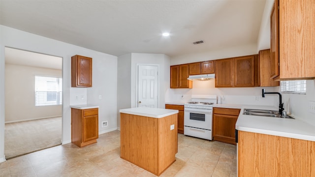 kitchen featuring white range oven, a kitchen island, and sink