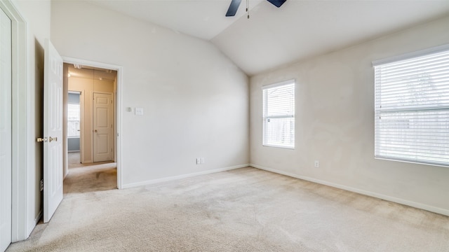 carpeted spare room with lofted ceiling and ceiling fan