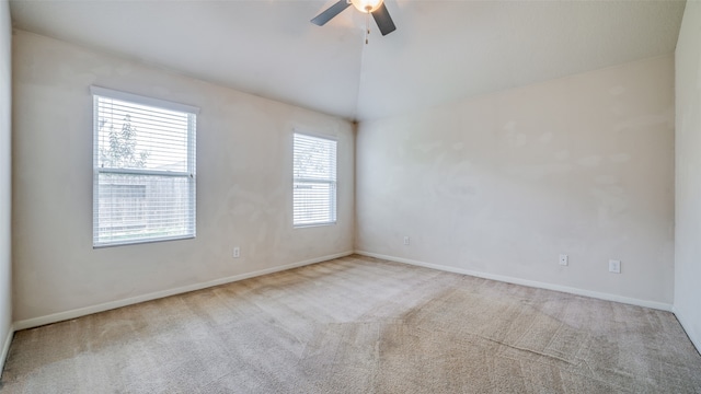 carpeted empty room with lofted ceiling, plenty of natural light, and ceiling fan