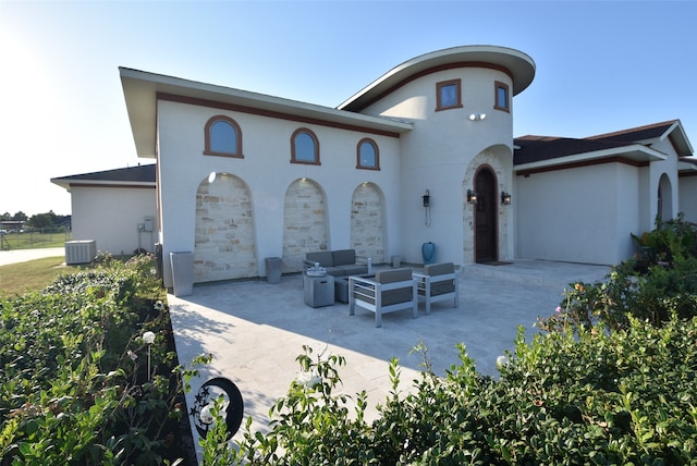 view of front of house featuring outdoor lounge area, central AC unit, and a patio