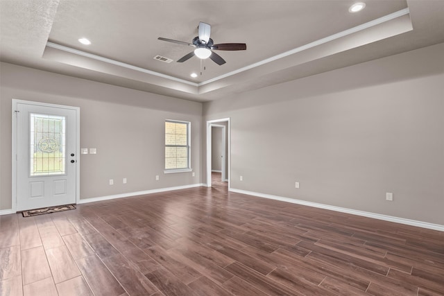 spare room with crown molding, a raised ceiling, ceiling fan, and dark hardwood / wood-style flooring