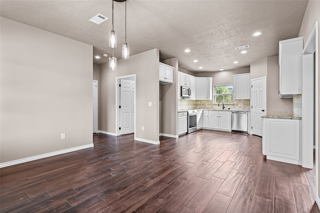 kitchen featuring appliances with stainless steel finishes, dark wood-type flooring, and white cabinets