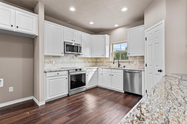 kitchen with appliances with stainless steel finishes, white cabinetry, sink, and dark hardwood / wood-style floors