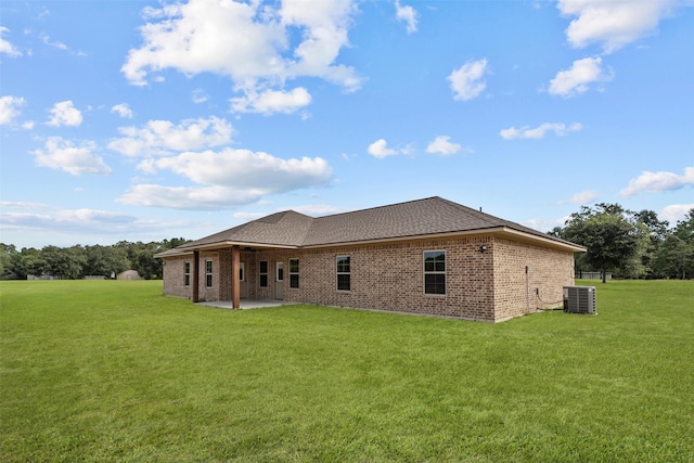 back of property with central AC, a lawn, and a patio area