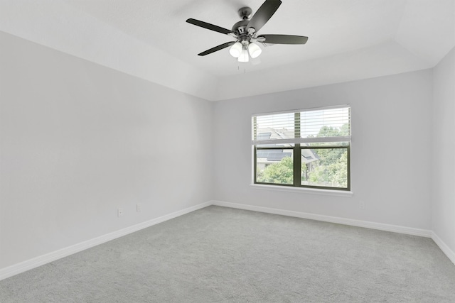 empty room featuring a tray ceiling, ceiling fan, and carpet floors