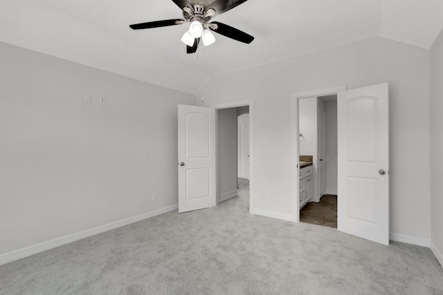 unfurnished bedroom with light colored carpet, lofted ceiling, ensuite bathroom, and ceiling fan