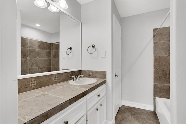 bathroom with tiled shower / bath combo and vanity