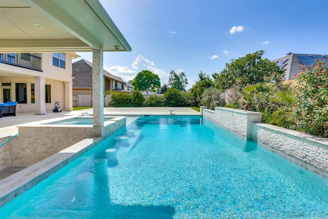 view of swimming pool featuring a patio and an in ground hot tub