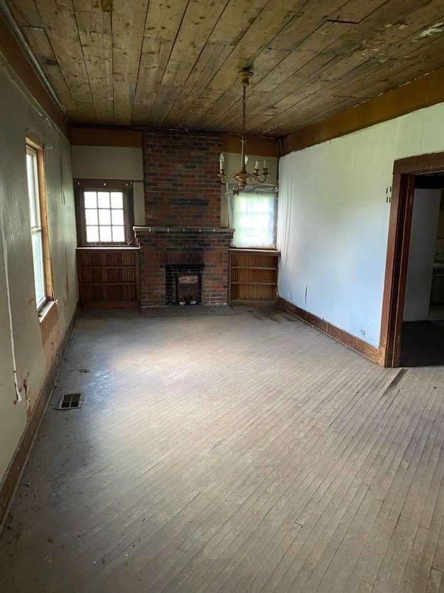 unfurnished living room with a fireplace, hardwood / wood-style flooring, and plenty of natural light