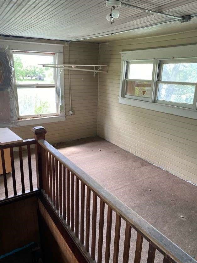 interior space with a healthy amount of sunlight and wooden walls