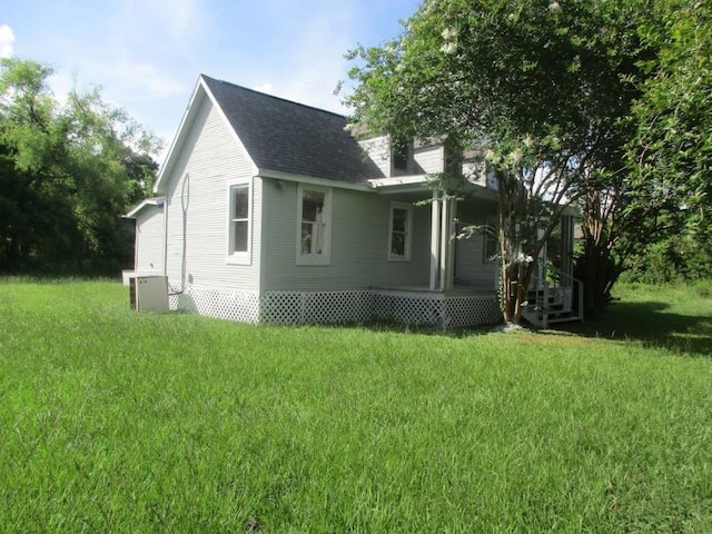 view of side of property featuring a yard and central AC unit