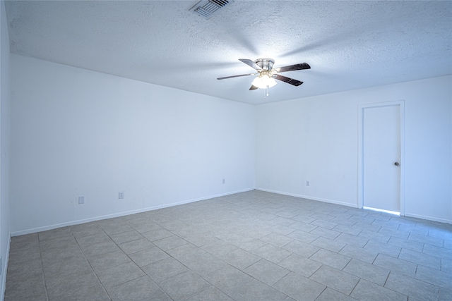 empty room with ceiling fan and a textured ceiling