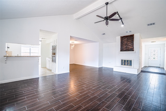 unfurnished living room featuring ceiling fan, beamed ceiling, high vaulted ceiling, and a fireplace