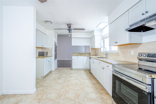 kitchen with ceiling fan, sink, appliances with stainless steel finishes, and white cabinets