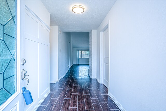 hall with a textured ceiling